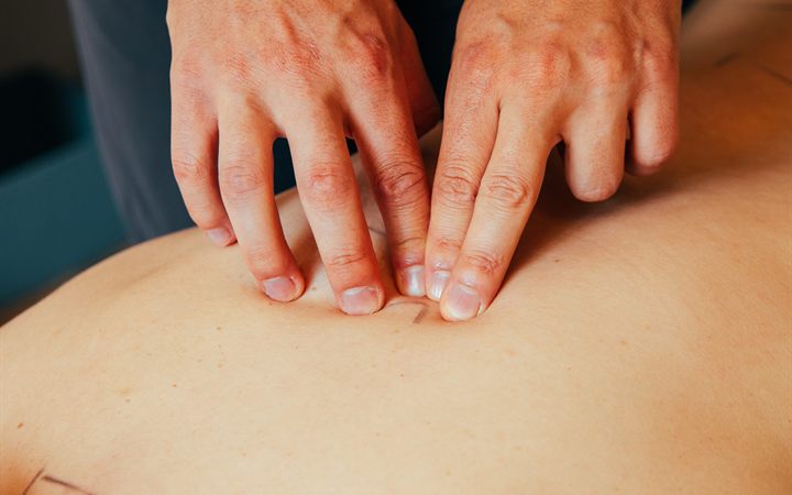 Le mani del chiropratico sulla schiena durante un aggiustamento